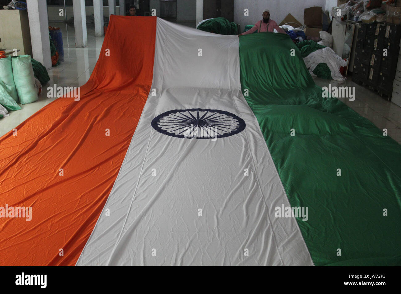 MUMBAI, INDE - Le 10 août : un travailleur dans une usine du pavillon qui touche finale au tricolore, le 8 août 2017 à Mumbai, Inde. Les marchés de la ville sont à la date de l'indépendance des marchandises y compris les globes décoratifs tricolore, caps et lots. Photo via Newscom Banque D'Images