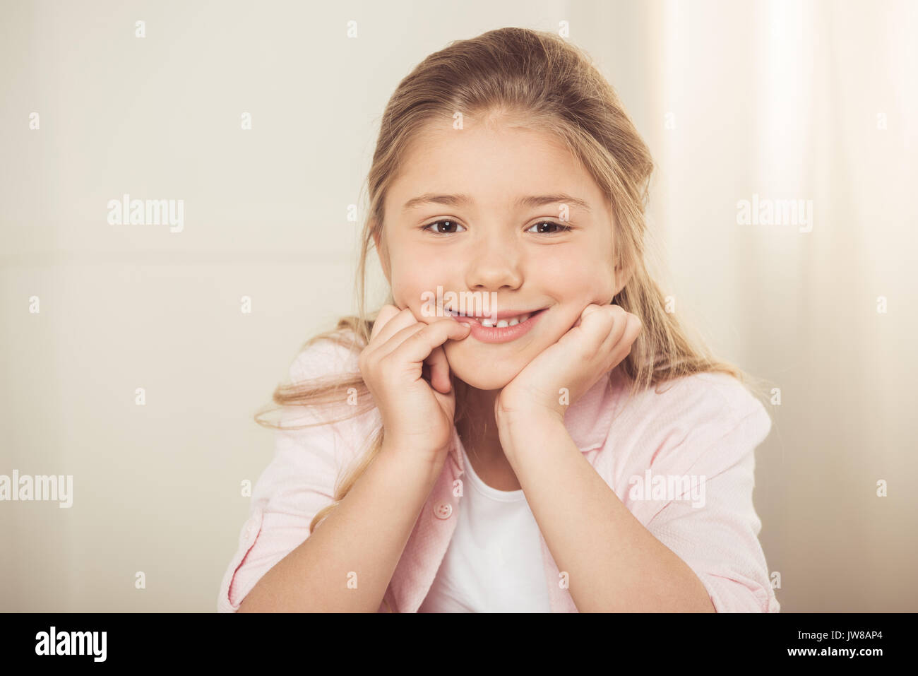 Close-up portrait of adorable petite fille smiling at camera Banque D'Images