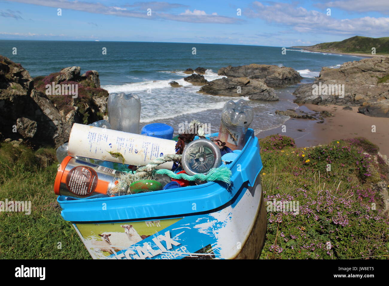 Tas de détritus en plastique nettoyé de Killintringan beach à Dumfries and Galloway de détritus en premier plan et de plage et de ciel bleu en arrière-plan Banque D'Images