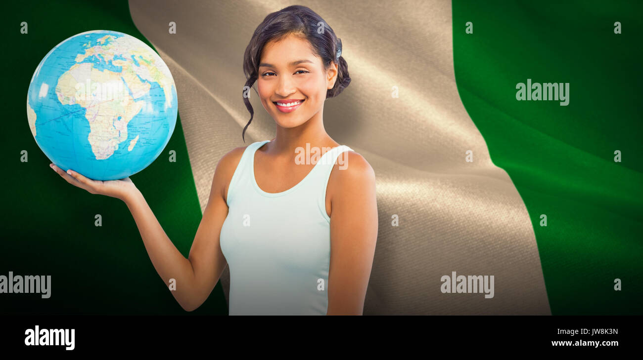 Jolie femme montrant globe contre drapeau national nigérian générés numériquement Banque D'Images
