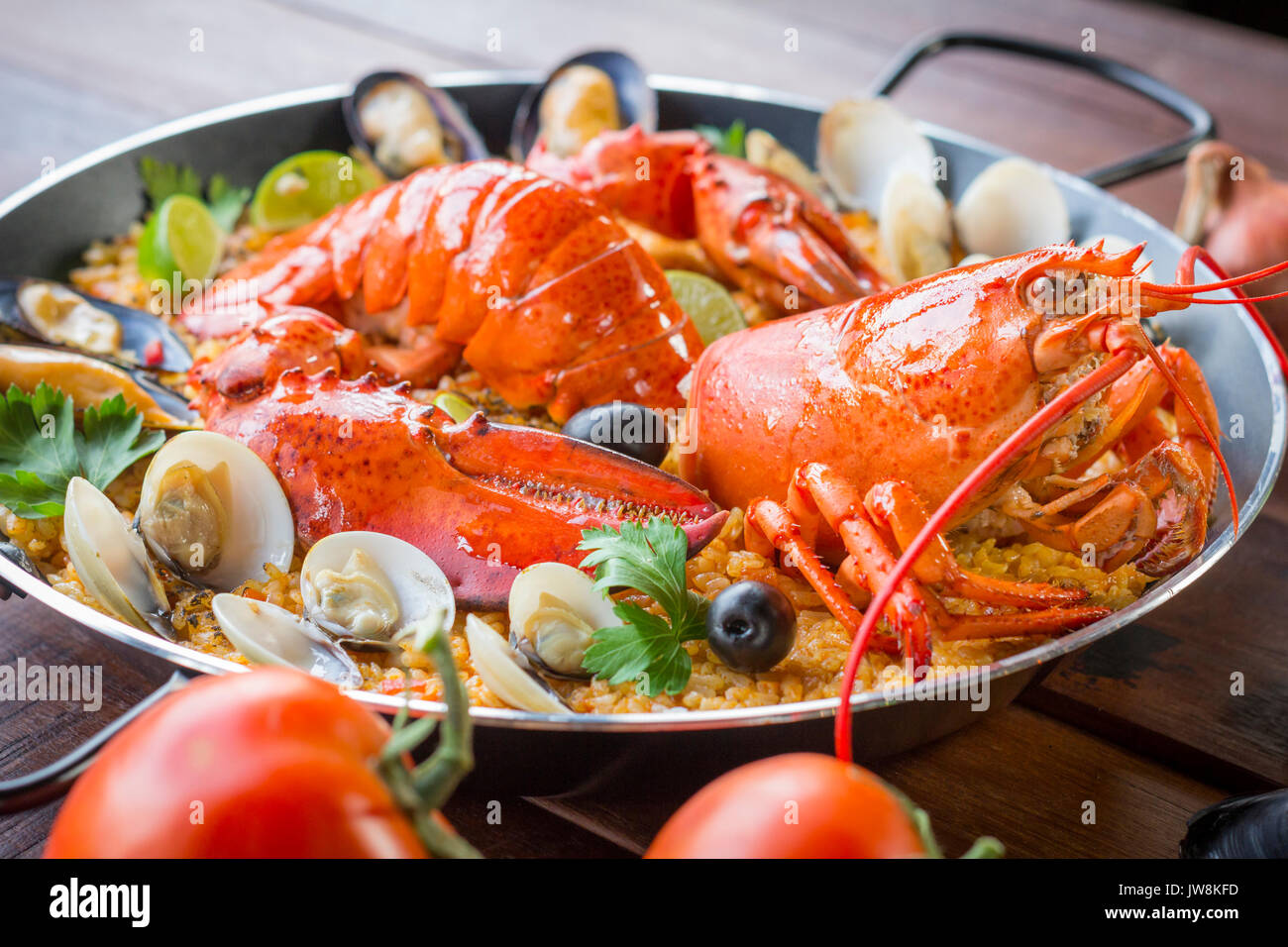 La paella de Valence de fruits de mer gastronomique avec des langoustines, des palourdes, moules et calamars sur salé riz safrané avec les pois et les tranches de citron, vue en gros Banque D'Images