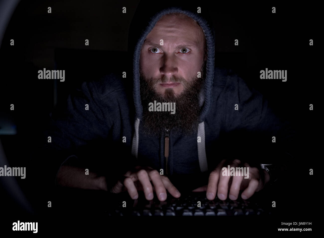 Dans exécutif hoodie working at desk in office Banque D'Images