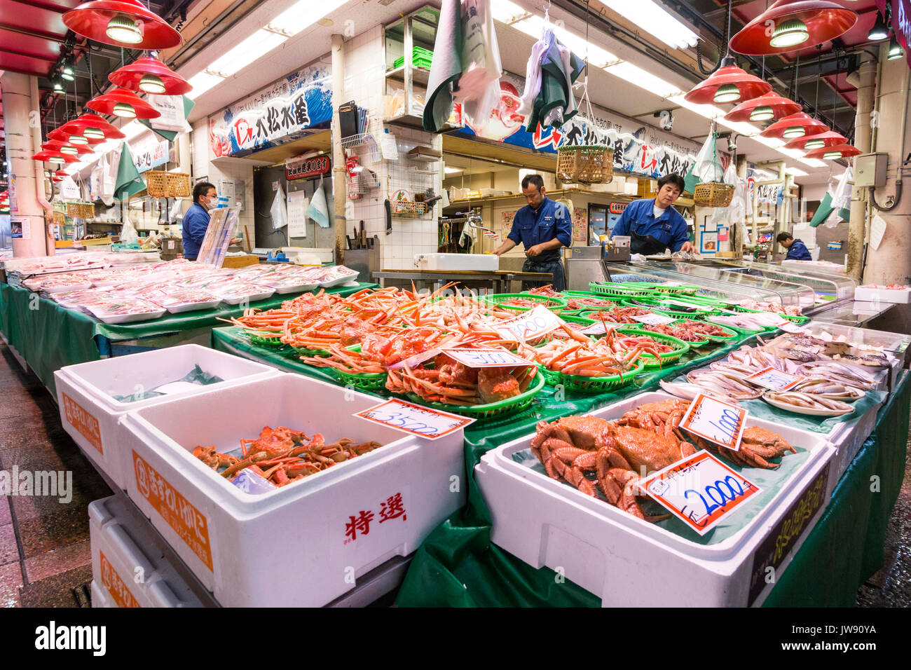 Des contenants remplis de gros crabes orange en vente sur le poisson-vendeurs au marché de produits frais à l'intérieur, Omicho, Kanazawa, Japon. Banque D'Images
