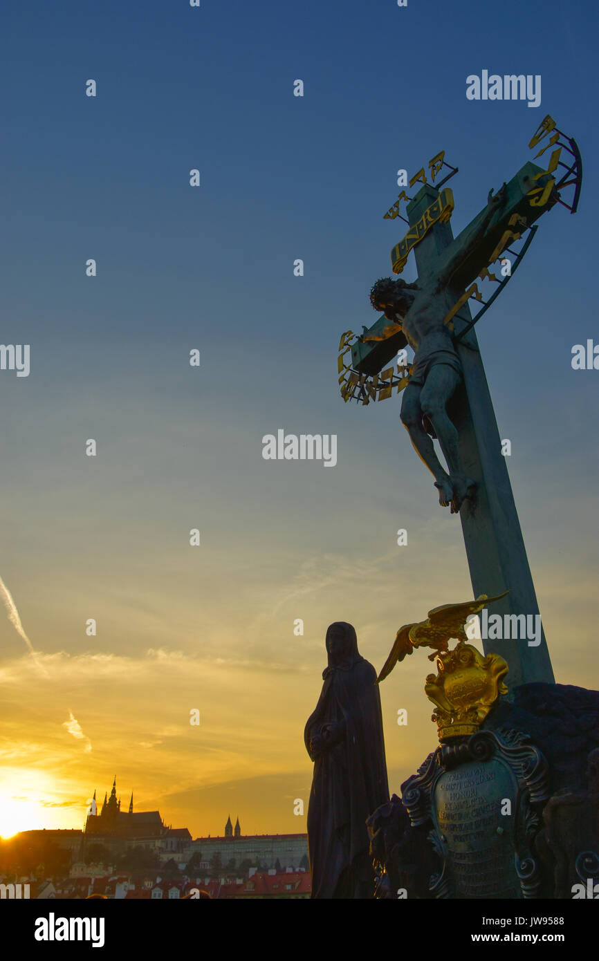 La silhouette de la statue du Christ sur la croix sur le pont Charles au coucher du soleil à Prague, République Tchèque Banque D'Images
