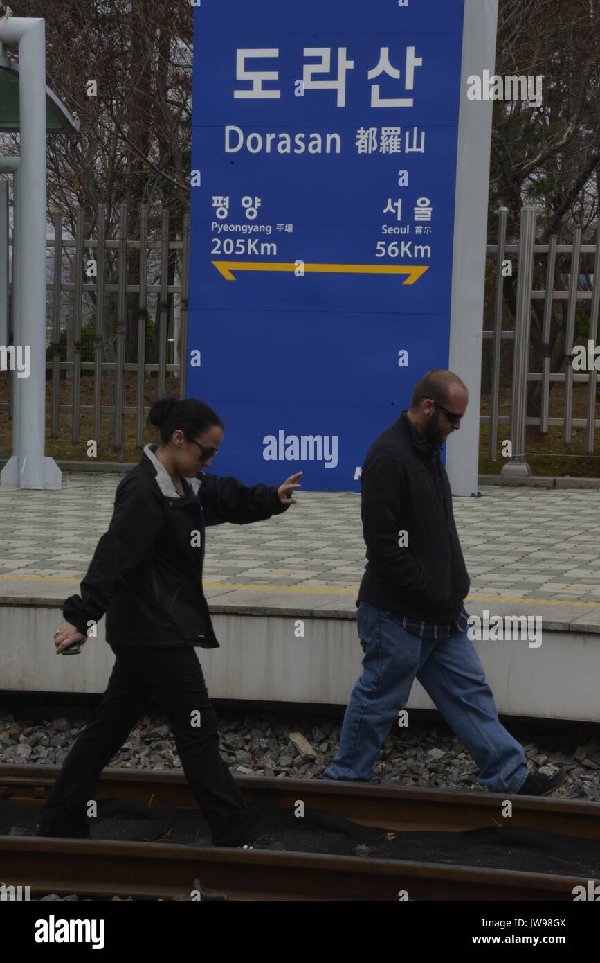 Les touristes à pied sur une ligne de chemin de fer à la gare la plus proche de la Corée du Nord, la gare de Dorasan, sud-coréenne de l'espoir pour liaison ferroviaire de la Corée du Nord, tandis que d'une visite guidée de la délicate zone démilitarisée (DMZ) dans le district de Paju Corée du Sud, 28 mars 2013. La ligne de chemin de fer a été construit dans l'espoir qu'il ne relie les deux Corée par la capitale nord-coréenne Pyyongyang (205km) et à la Chine et la Russie. Cependant, la ligne ferroviaire Gyeongui s'arrête à Dorasan, comme seulement un essai de fonctionnement et les trains de marchandises dirigée à complexe industriel de Kaesong en 2007 n'ont jamais vu brève opération. La station touristique est maintenant Banque D'Images