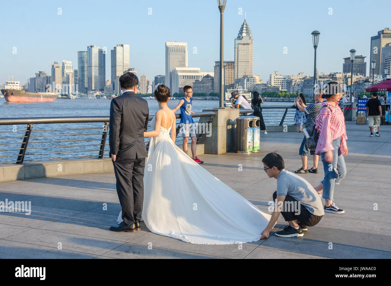 Un couple de poser pour des photos de mariage sur les rives de la rivière Haungpu à Shanghai, Chine. Banque D'Images