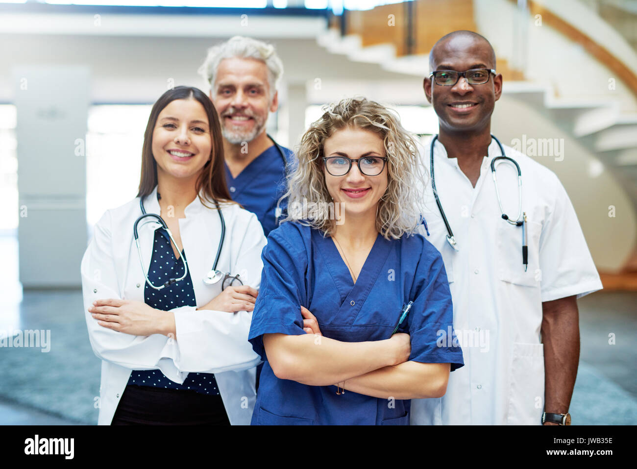 Smiling medical team with arms crossed standing dans une clinique et à la recherche à l'appareil photo. Banque D'Images
