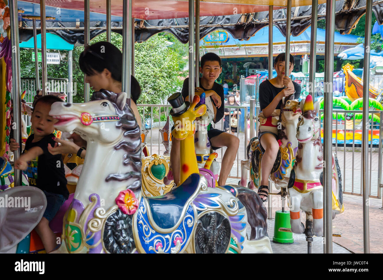 Les enfants voyagent d'un manège dans le Parc du Peuple à Shanghai, Chine. Banque D'Images