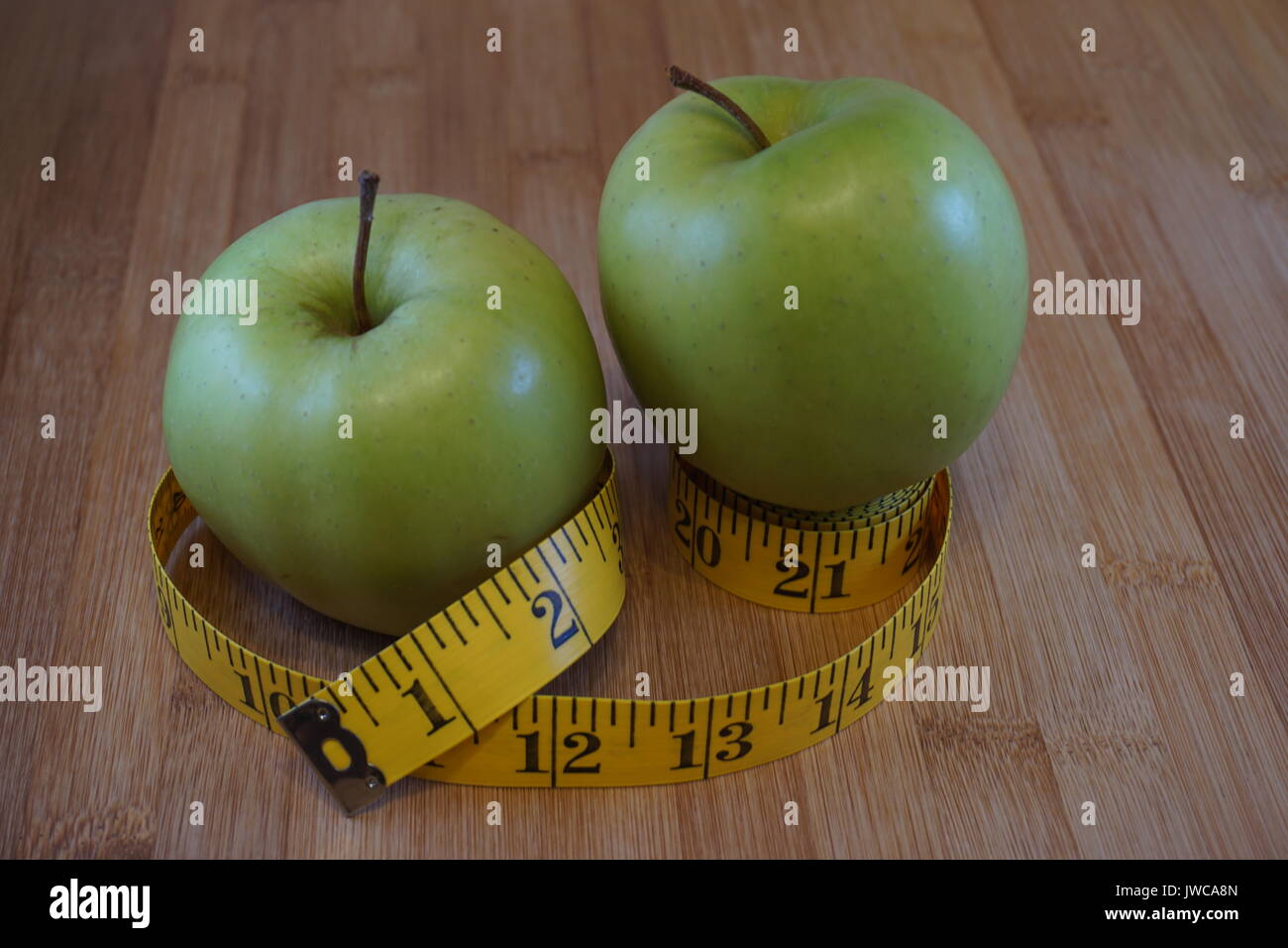 La pomme verte sur table en bois avec ruban de mesure couture Banque D'Images