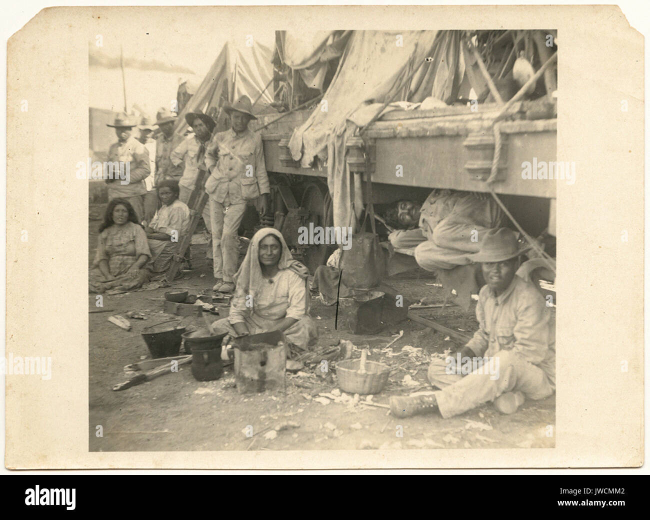 Des soldats mexicains au camp sous un wagon plat. - Les troupes de la frontière américaine et de la Révolution Mexicaine Banque D'Images