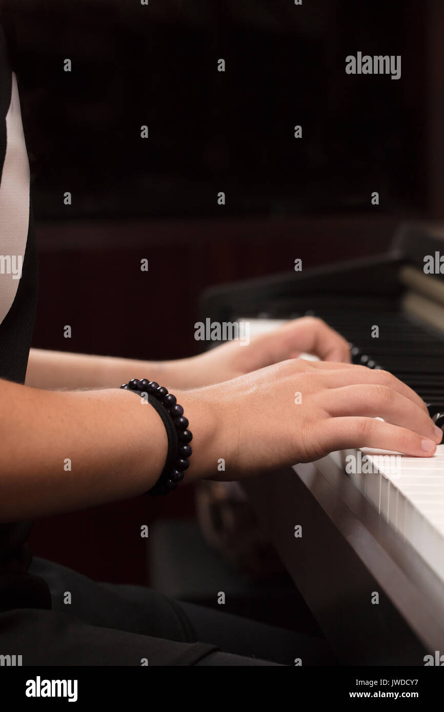 Jeune personne de jouer et pratiquer le piano sur les touches noires et blanches Banque D'Images