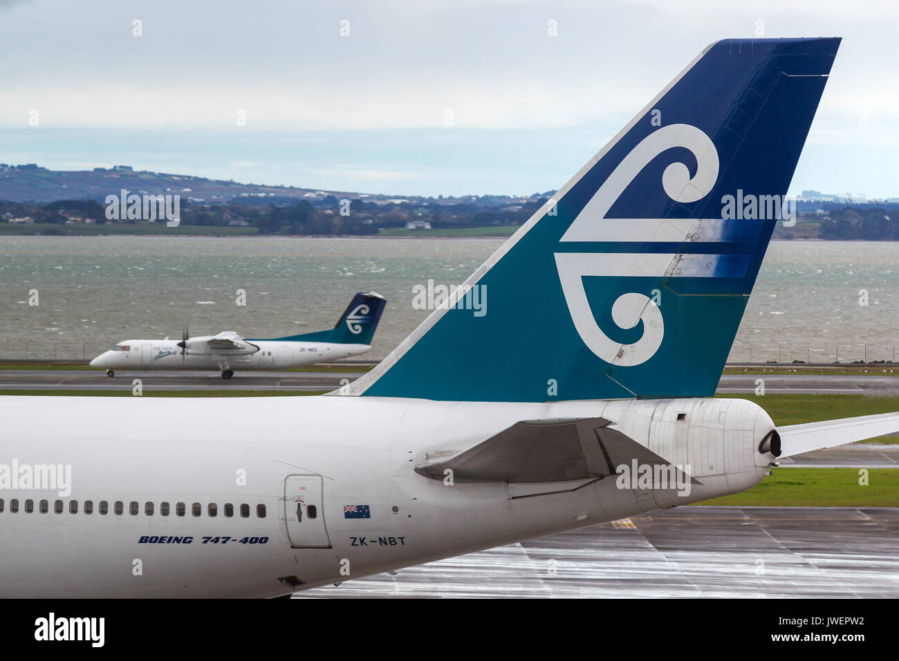 Air New Zealand Boeing 747-419 zk-nbt sur le tarmac de l'aéroport international d'Auckland avec un air new zealand dash 8 derrière. Banque D'Images