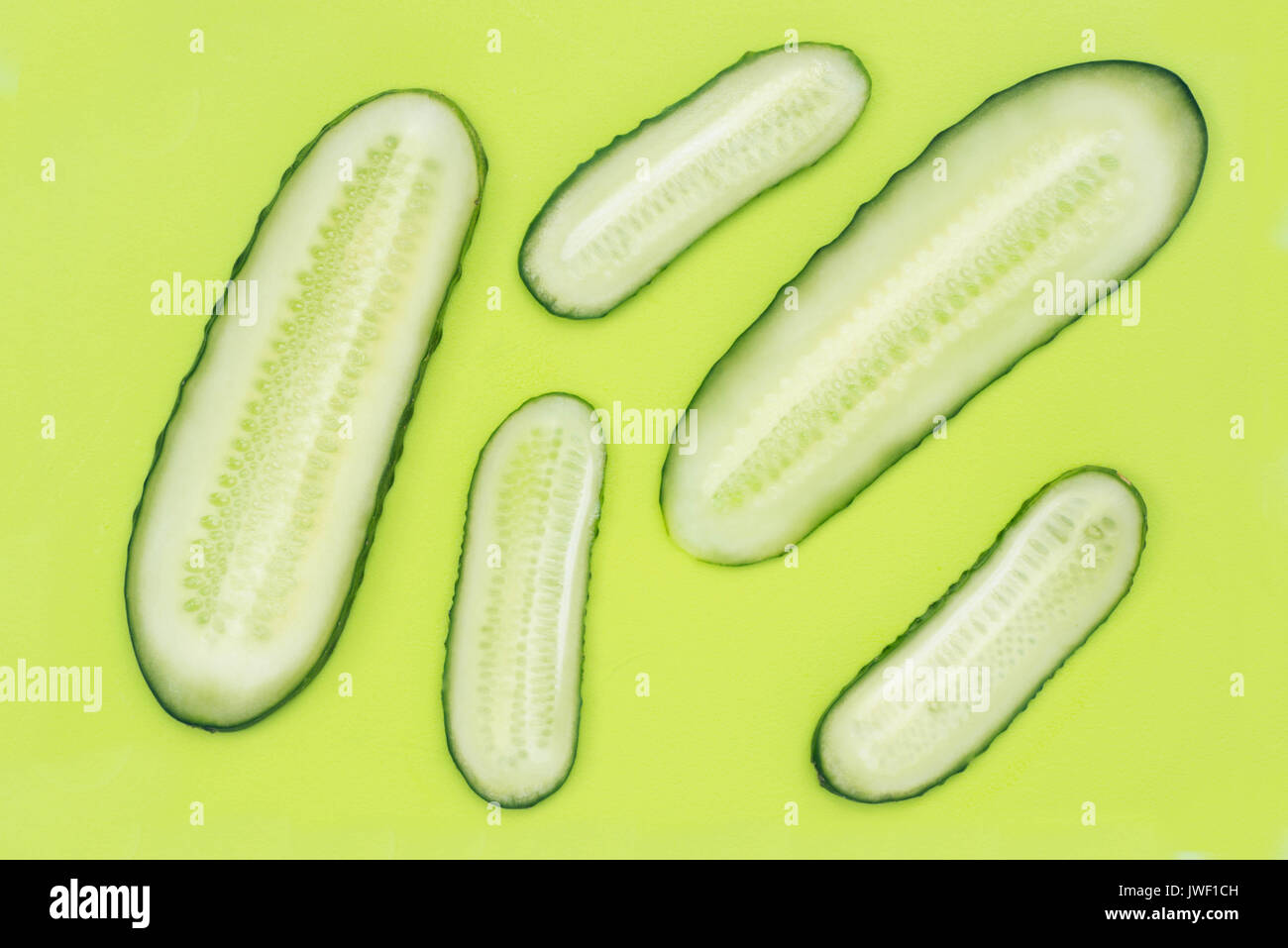 Des tranches de concombre sur une planche à découper en plastique vert Vue de dessus Banque D'Images