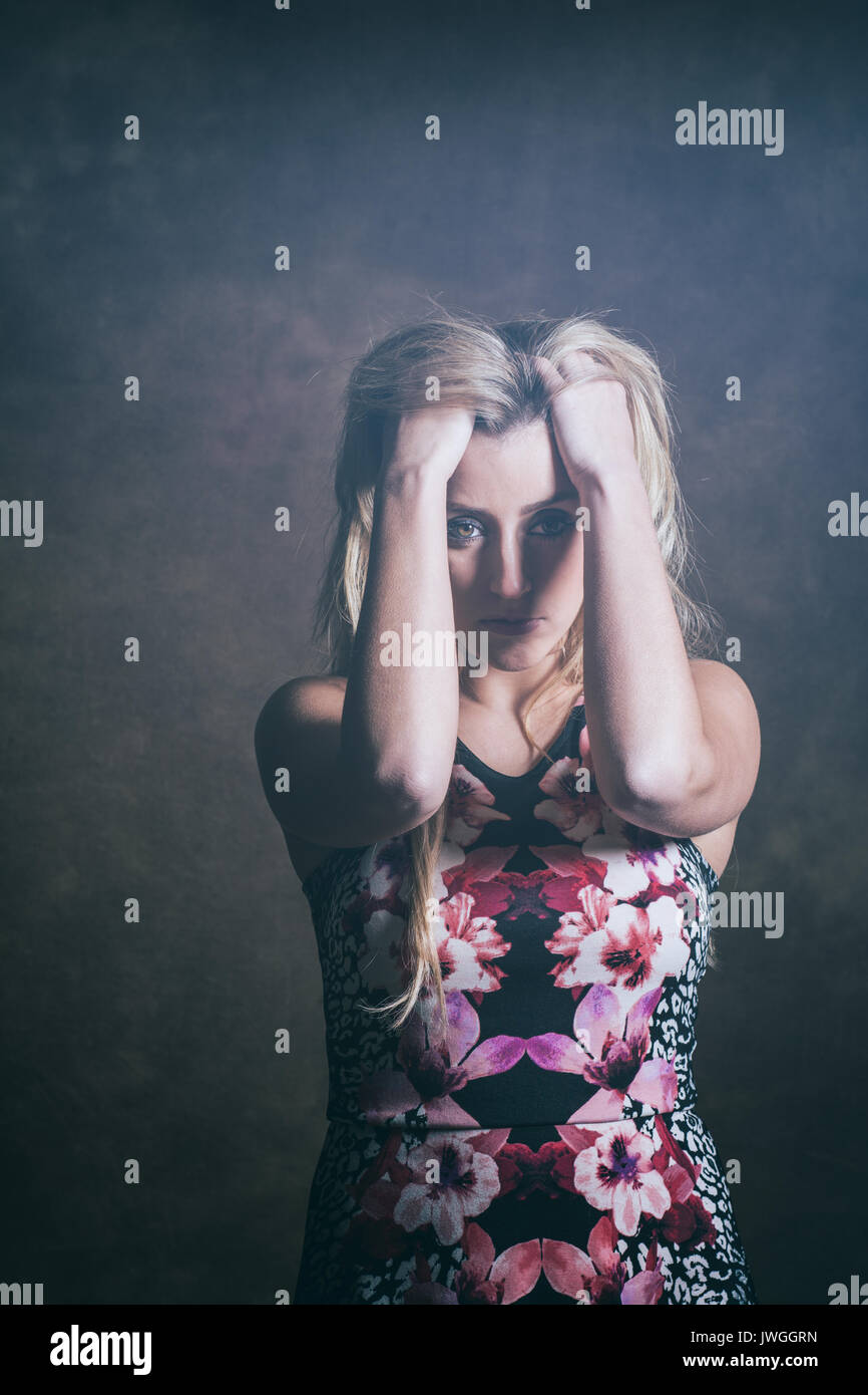 Frustrés blonde woman head in hands Banque D'Images