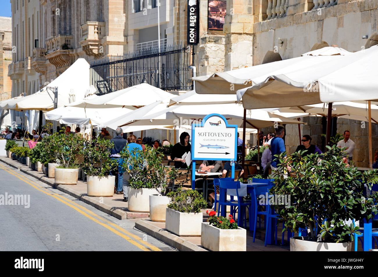 Les touristes se détendre à la terrasse d'un café au bord de l'eau, Vittoriosa (Birgu), de Malte, de l'Europe. Banque D'Images