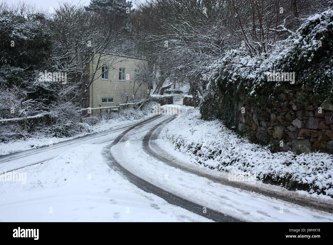 Îles Anglo-Normandes. L'Alderney. Scène d'hiver de neige-couvertes et cottage country lane. Banque D'Images