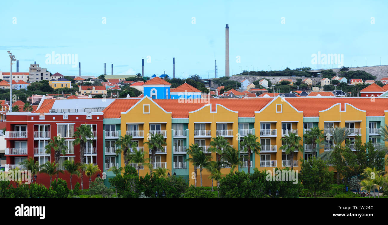 Resort colorés avec des raffineries de pétrole en arrière-plan sur Curacao Banque D'Images