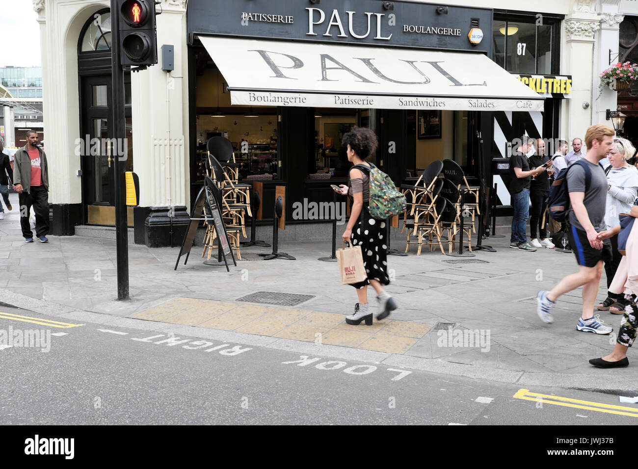 Une femme tenant des piétons marchant sur téléphone mobile Chartreuse Street passé PAUL boulangerie restaurant Smithfield Clerkenwell Londres UK KATHY DEWITT Banque D'Images