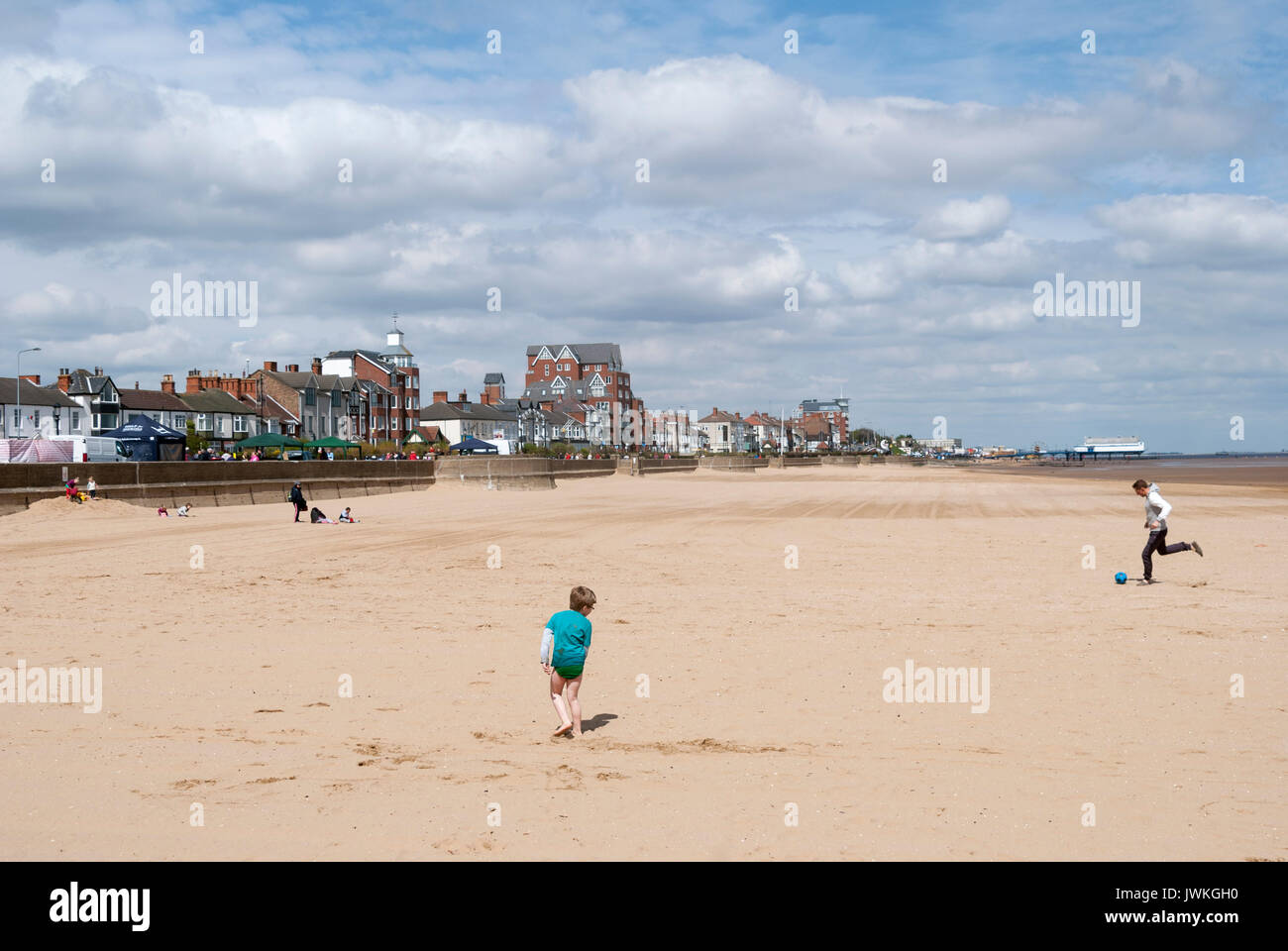 Famille jouant au football sur la plage, Tide Out, English Coastal Resort, Summertime, Seaside Town, Cleethorpes, sable, sortie en famille, jetée de Seaside Banque D'Images