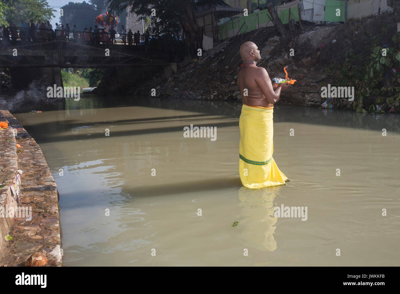 Un homme fait une offrande dans une rivière au cours du festival hindou Thaipusam à Batu Caves temple à Kuala Lumpur. Thaipusam, une fête qui honore le dieu Murugan, est censé apporter santé et prospérité à des pèlerins prêts à faire le voyage jusqu'au temple et donner des offrandes. La Malaysian Thaipusam est le plus grand festival du genre au monde, avec plus de 1,5 millions de pèlerins et touristes présents. Banque D'Images