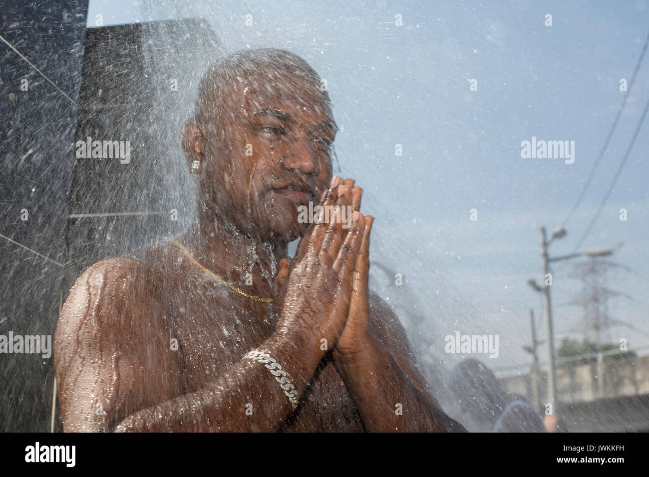 Un homme est d'avoir un bain rituel au cours de l'Thaipusam fête hindoue à Batu Caves temple à Kuala Lumpur. Thaipusam, une fête qui honore le dieu Murugan, est censé apporter santé et prospérité à des pèlerins prêts à faire le voyage jusqu'au temple et donner des offrandes. La Malaysian Thaipusam est le plus grand festival du genre au monde, avec plus de 1,5 millions de pèlerins et touristes présents. Banque D'Images