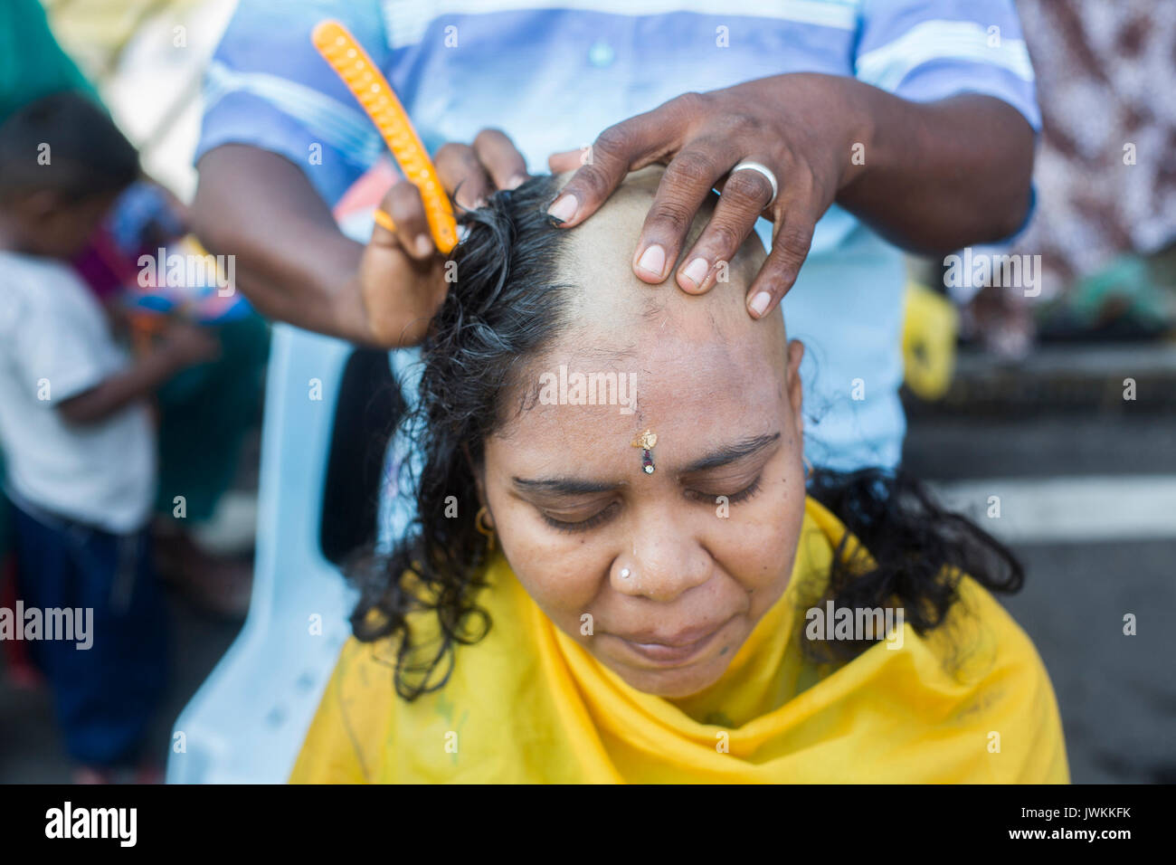 Une femme hindoue est d'avoir un rituel rasage de la tête pendant l'Thaipusam fête hindoue à Batu Caves temple à Kuala Lumpur. Thaipusam, une fête qui honore le dieu Murugan, est censé apporter santé et prospérité à des pèlerins prêts à faire le voyage jusqu'au temple et donner des offrandes. La Malaysian Thaipusam est le plus grand festival du genre au monde, avec plus de 1,5 millions de pèlerins et touristes présents. Banque D'Images