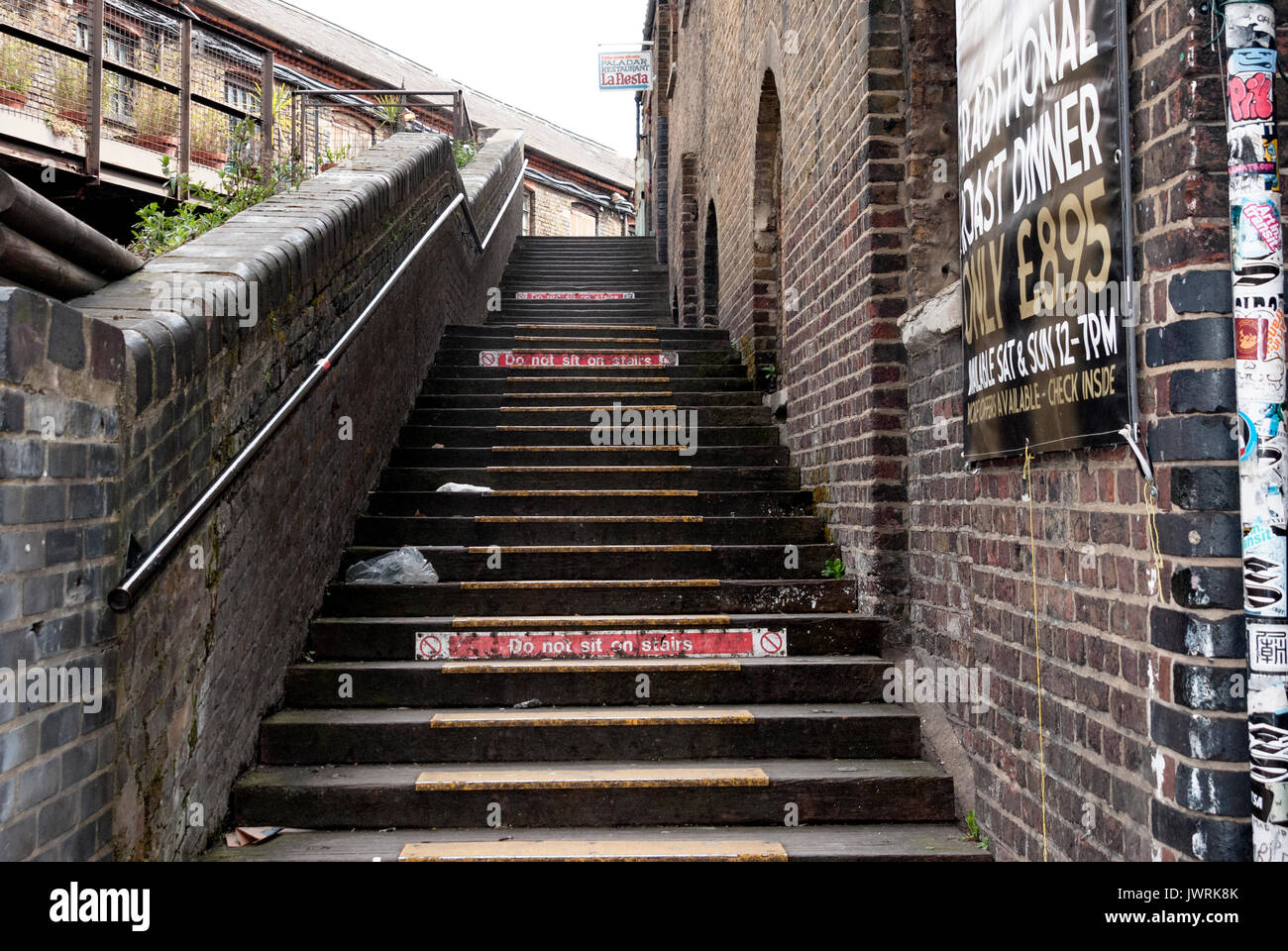 Londres Angleterre, Camden Town, Camden Lock, marché Camden, chemin de fer en brique ascendant, autocollants sur le poteau, affiche, panneau d'avertissement, balustrade, litière Banque D'Images