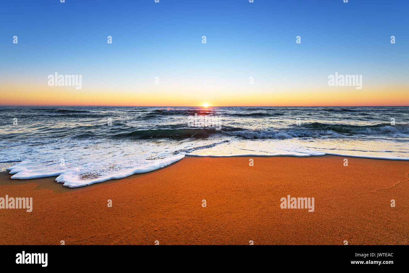 L'océan majestueux coucher du soleil avec une vague déferlante. Banque D'Images