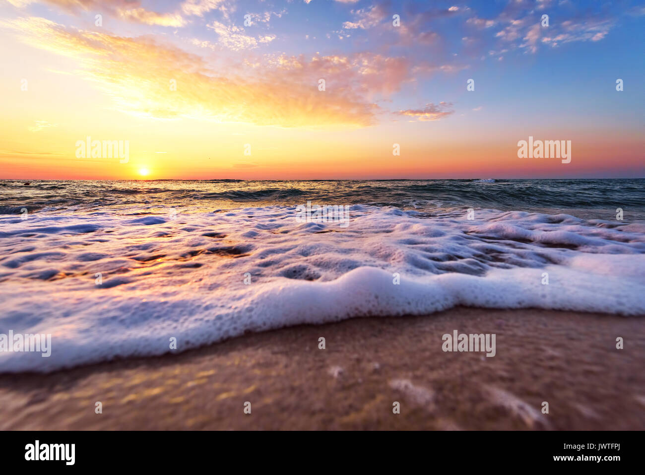 L'océan majestueux coucher du soleil avec une vague déferlante. Banque D'Images