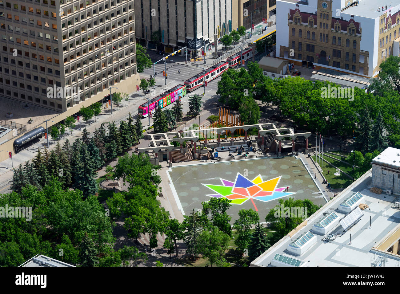 Une feuille d'érable de couleur intégré à l'Olympic Plaza avec un train de voyageurs en transit de Calgary à Calgary Alberta Canada de la tour de Calgary Banque D'Images