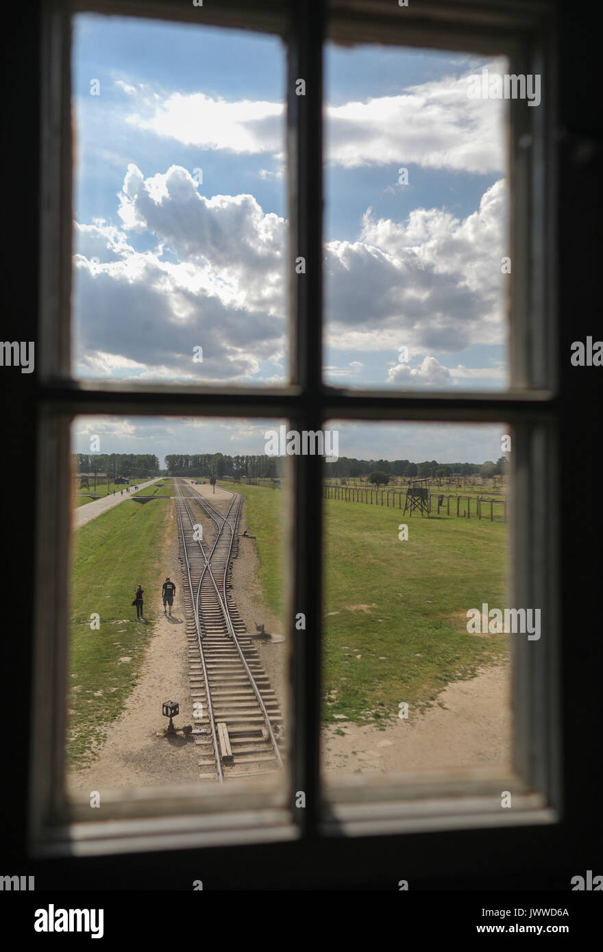 Les visiteurs marchent à travers l'ancien camp de concentration d'Auschwitz-Birkenau à Oswiecim, Pologne, 26 juin 2017, photographiés à travers une fenêtre de la tour de guet. La principale organisation paramilitaire de l'Allemagne nazie, SS (Schutzstaffel, allumé. L'Escadron 'Protection'), a couru le camp de la mort et de concentration entre 1940 et 1945. Les personnes expulsées ont été choisis en différents groupes sur la rampe entre les pistes juste après leur arrivée à Birkenau. Les personnes qui n'ont pas été en mesure de travailler (les personnes âgées, faibles, femmes, enfants) sont parfois envoyés à la chambre à gaz sans enregistrement. Environ 1,1 à Banque D'Images