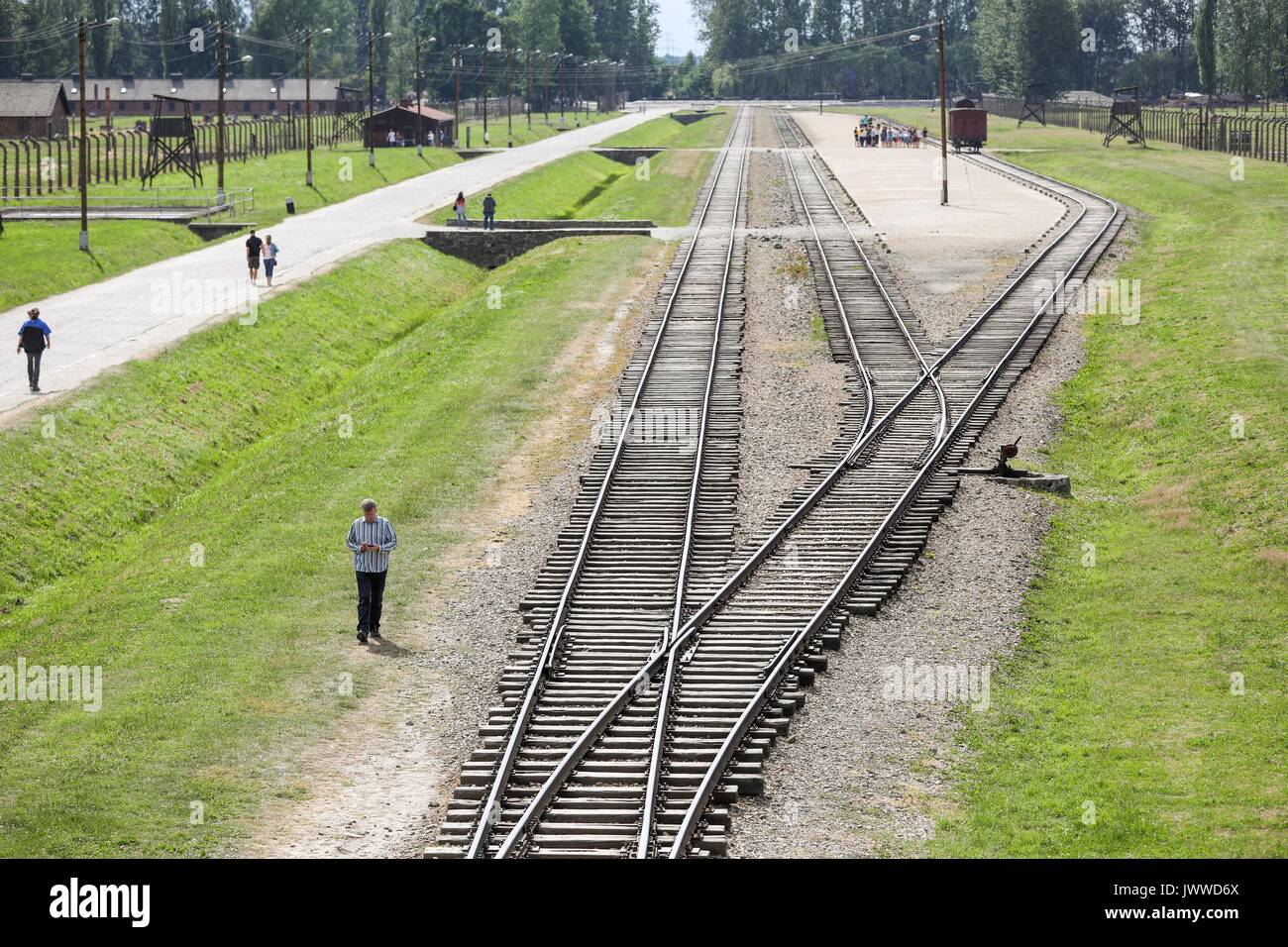 Les visiteurs marchent à travers l'ancien camp de concentration d'Auschwitz-Birkenau à Oswiecim, Pologne, 26 juin 2017. La principale organisation paramilitaire de l'Allemagne nazie, SS (Schutzstaffel, allumé. L'Escadron 'Protection'), a couru le camp de la mort et de concentration entre 1940 et 1945. Les personnes expulsées ont été choisis en différents groupes sur la rampe entre les pistes juste après leur arrivée à Birkenau. Les personnes qui n'ont pas été en mesure de travailler (les personnes âgées, faibles, femmes, enfants) sont parfois envoyés à la chambre à gaz sans enregistrement. Environ 1,1 à 1,5 millions de personnes, la plupart d'entre eux, ont être Juif Banque D'Images