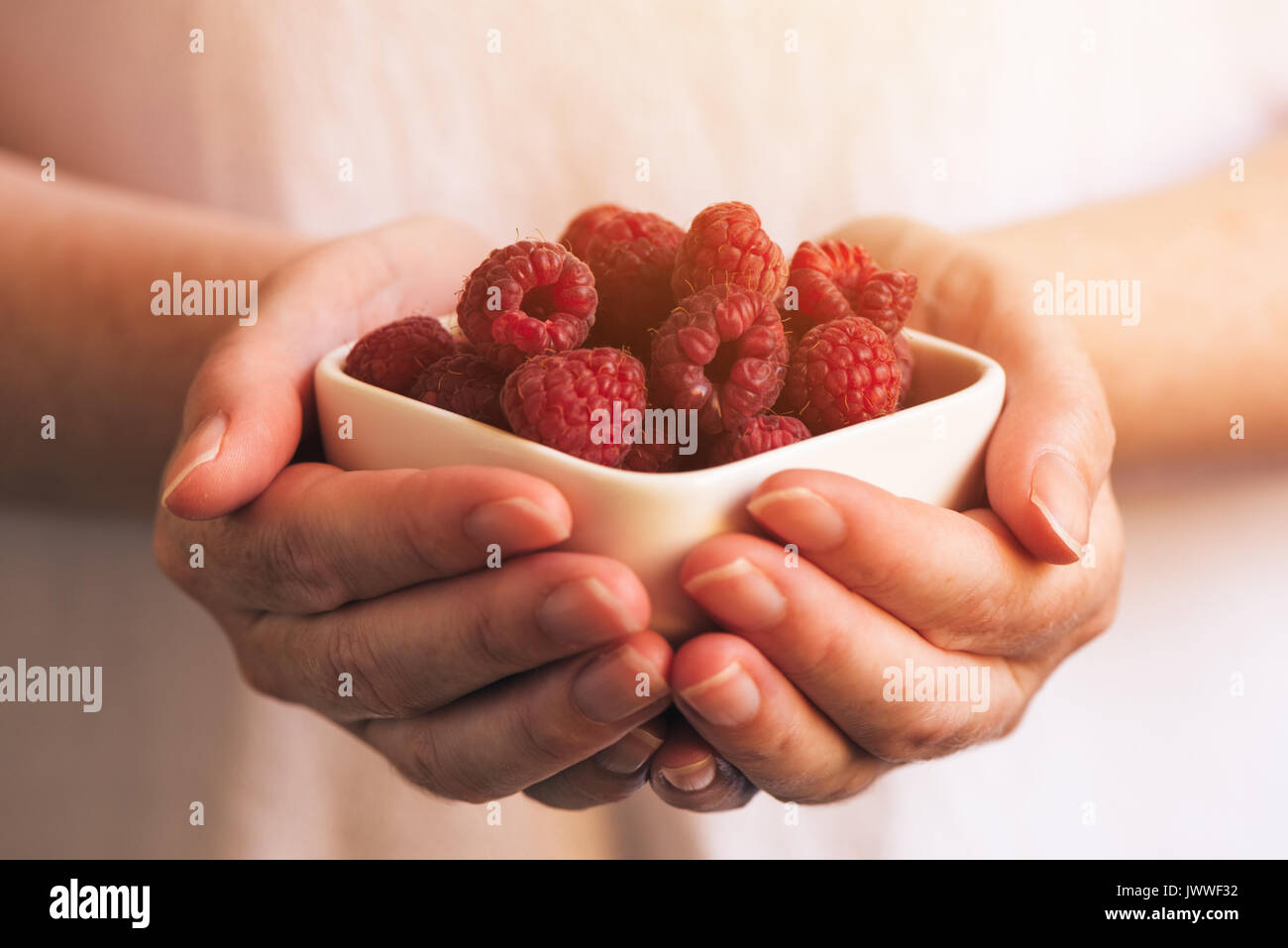 De la vaisselle avec des framboises dans femme mains, selective focus Banque D'Images