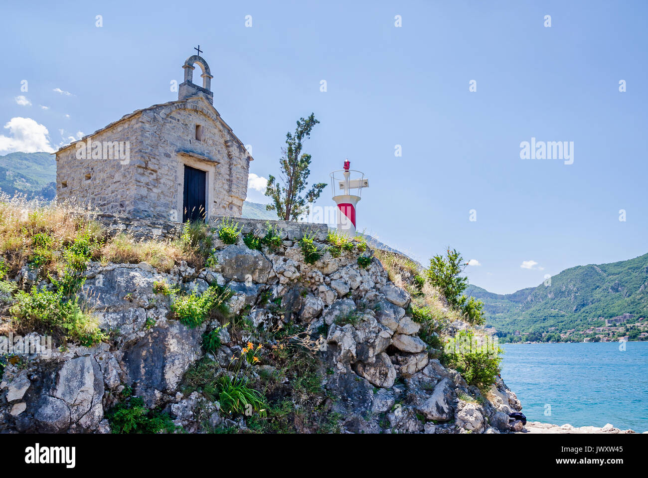 Une petite vieille chapelle et une tour d'éclairage de l'Institut de Biologie Marine à Kotor, Monténégro Banque D'Images