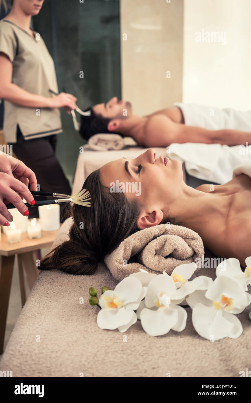Femme couchée détendue sur lit de massage au cours de traitement du visage Banque D'Images
