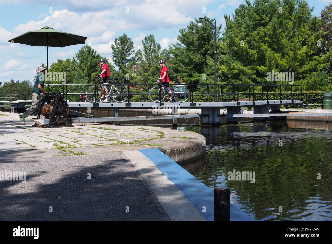 Deux cyclistes traverse le haut de la porte à l'écluse du canal Rideau, Université Carleton, Ottawa, Ontario, Canada. Banque D'Images