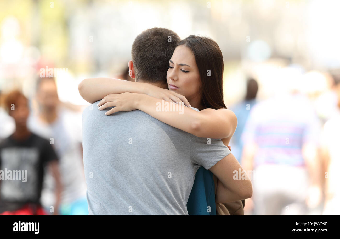 Mécontentement woman hugging son couple avec des problèmes sur la rue Banque D'Images