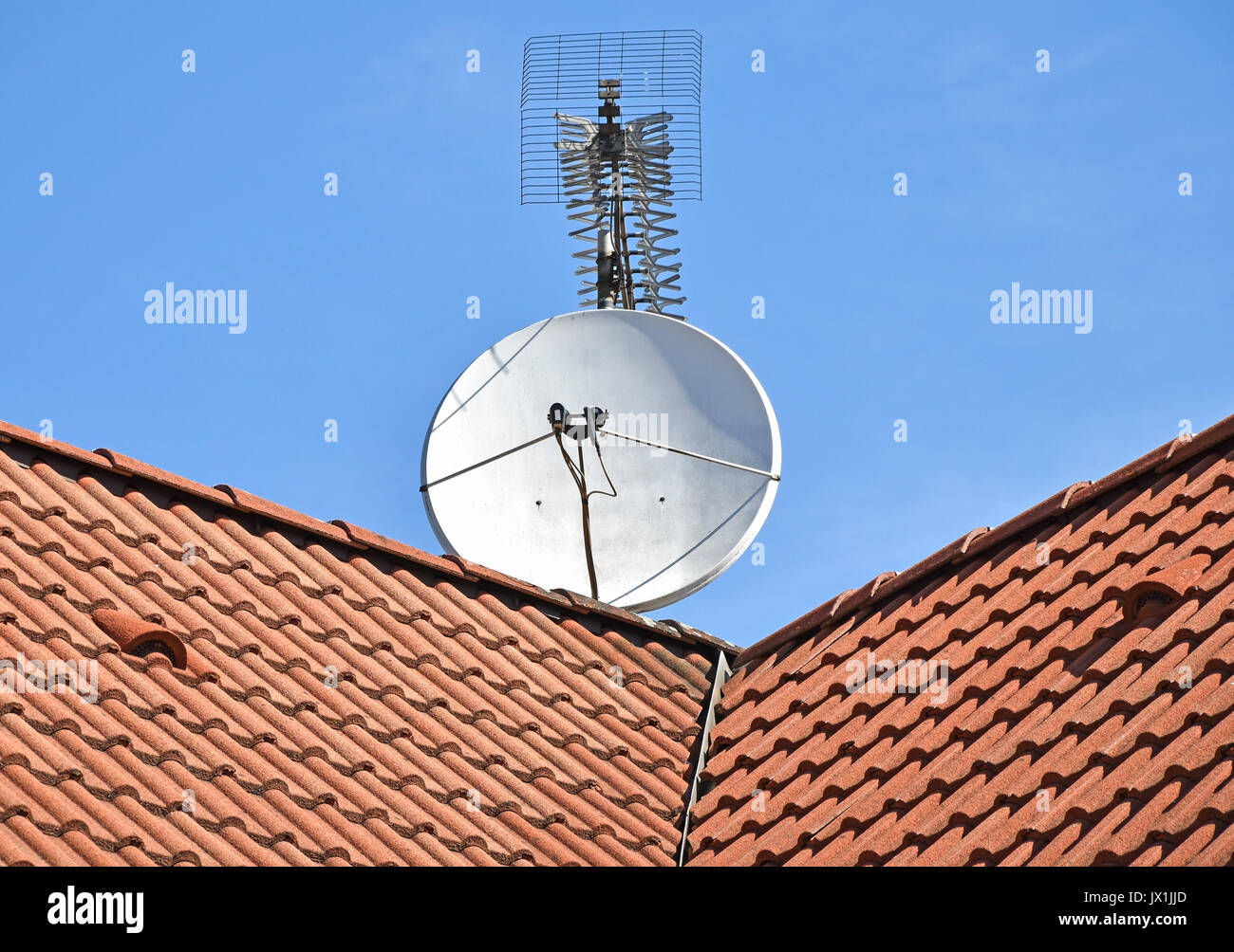 La parabole et antenne de télévision sur le toit d'un bâtiment Banque D'Images