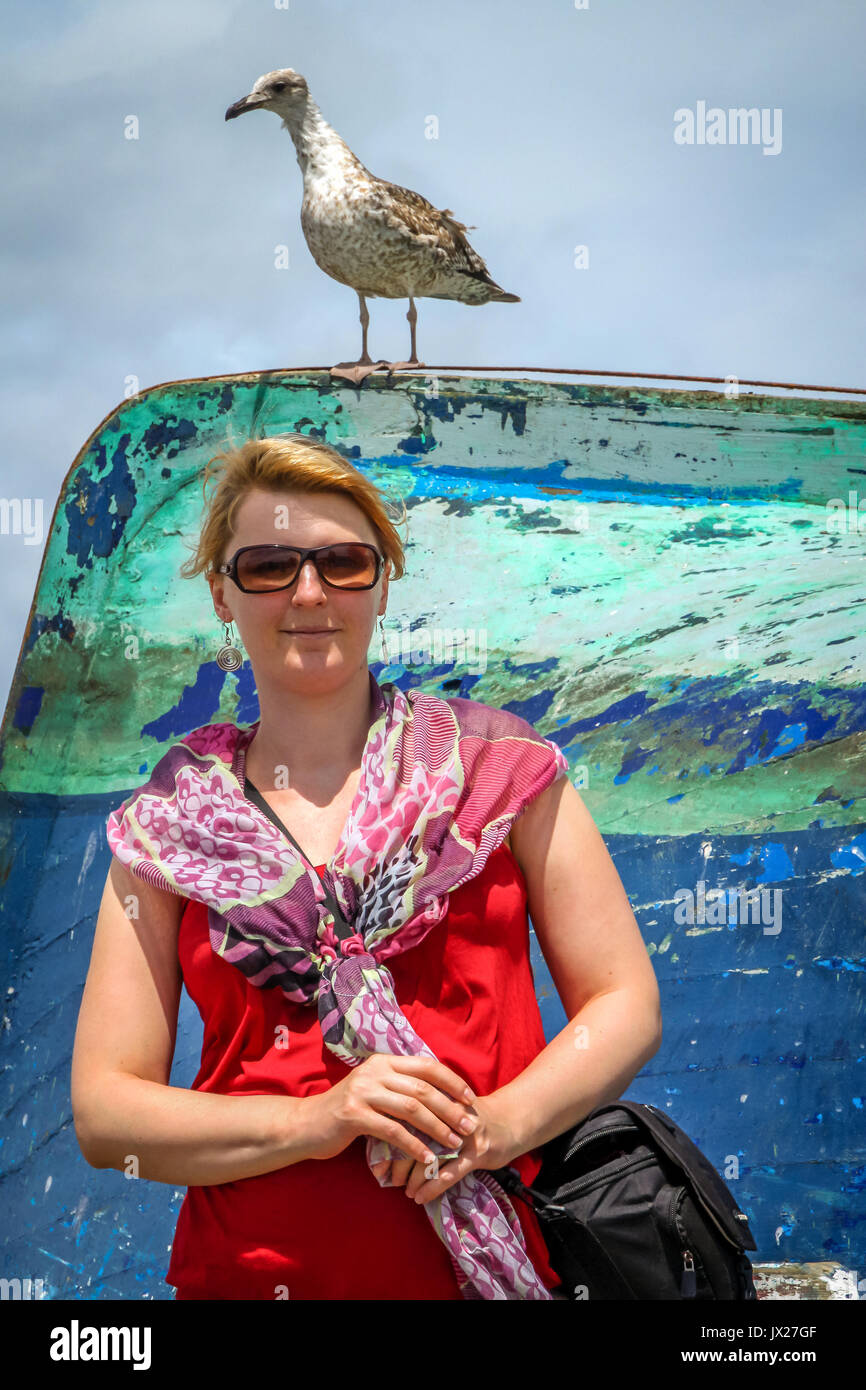 Femme posant pour une photo portrait avec mouettes derrière elle, Essaouira ville port, côte marocaine Banque D'Images