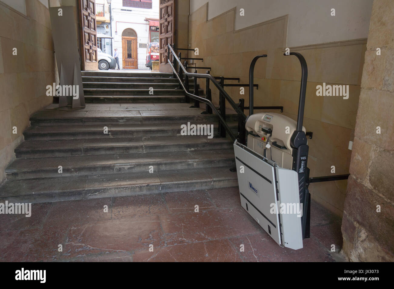 Un siège incliné, la mobilité en fauteuil roulant ascenseur, monte-escalier pour fauteuil roulant, pour l'accès en haut et en bas des escaliers d'une ancienne cour intérieure à une rue principale. Banque D'Images