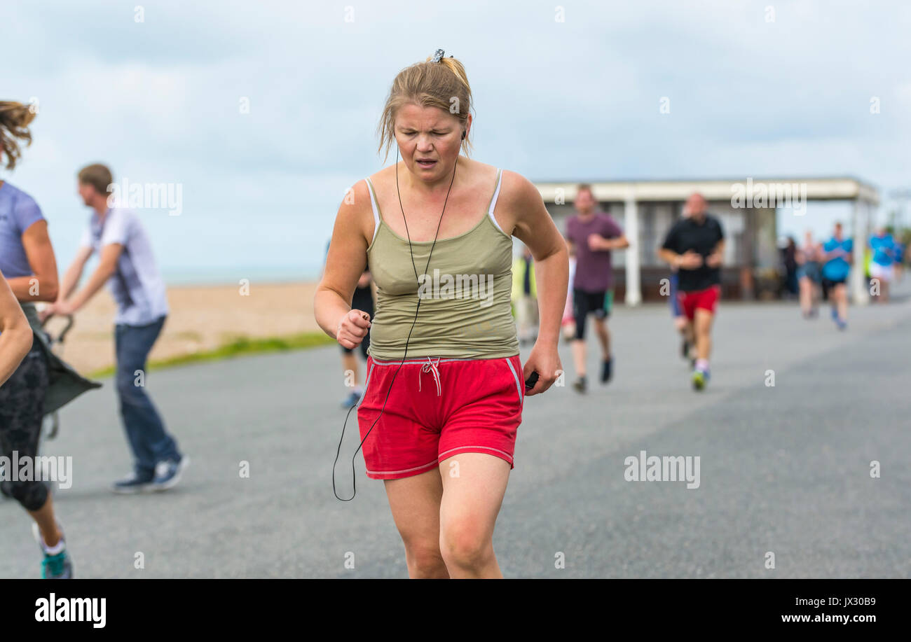 Jeune femme d'exécution sur la vitalité de l'événement hebdomadaire Parkrun à Worthing, West Sussex, Angleterre, Royaume-Uni. Banque D'Images Jeune femme d'exécution sur la vitalité de l'événement hebdomadaire Parkrun à Worthing, West Sussex, Angleterre, Royaume-Uni. Banque D'Images