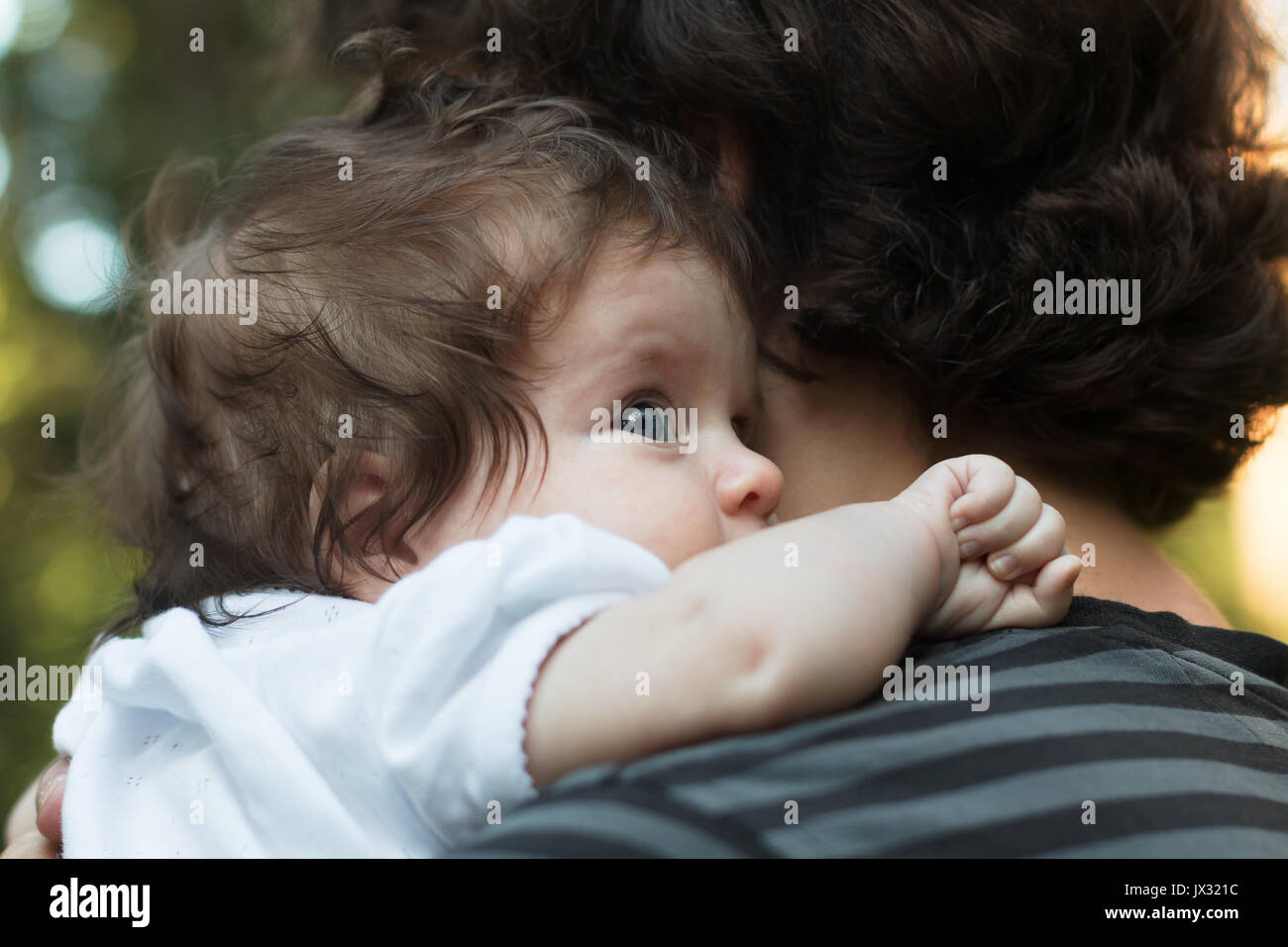 Petite fille se reposant sur l'épaule de son père. Happy sweet girl hugging son père sur le fond des forêts Banque D'Images