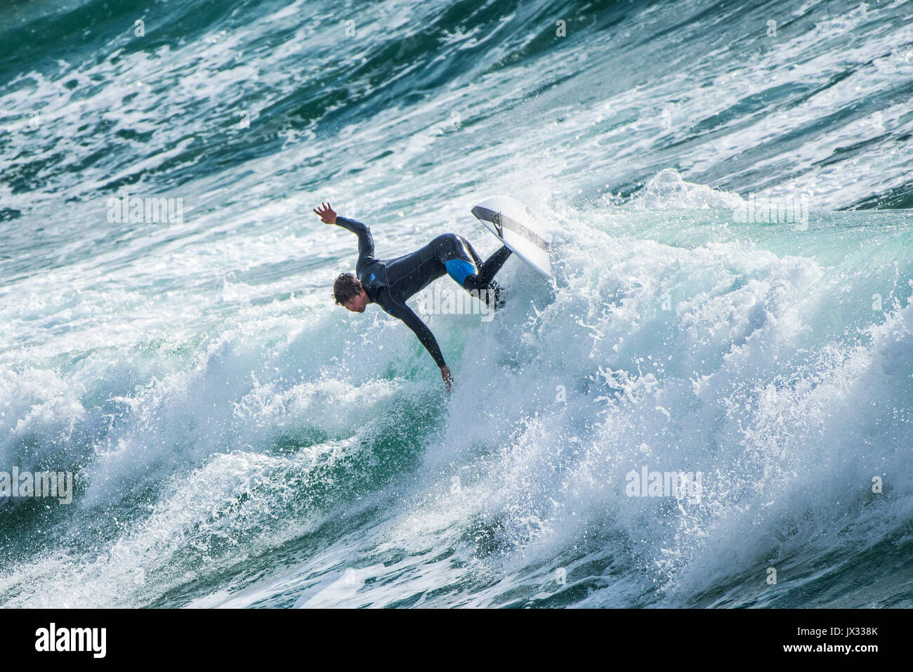 UK Surf. Un surfer une vague à dans Fistral Newquay, Cornwall. Banque D'Images