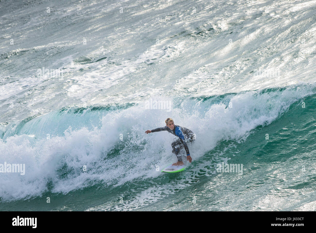 UK Surf. Un surfer une vague à dans Fistral Newquay, Cornwall. Banque D'Images
