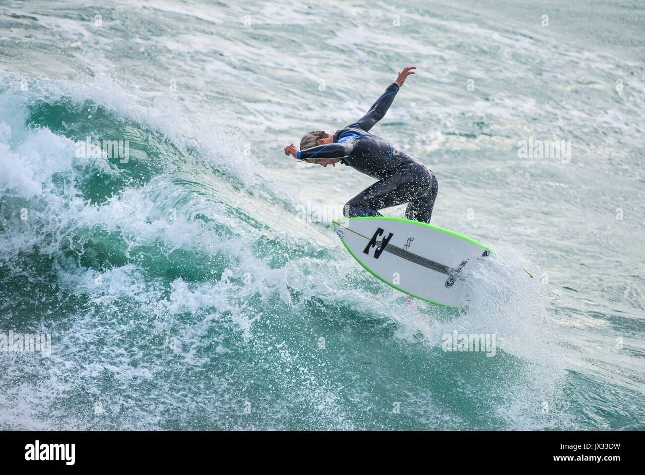 UK Surf. Un surfer une vague à dans Fistral Newquay, Cornwall. Banque D'Images