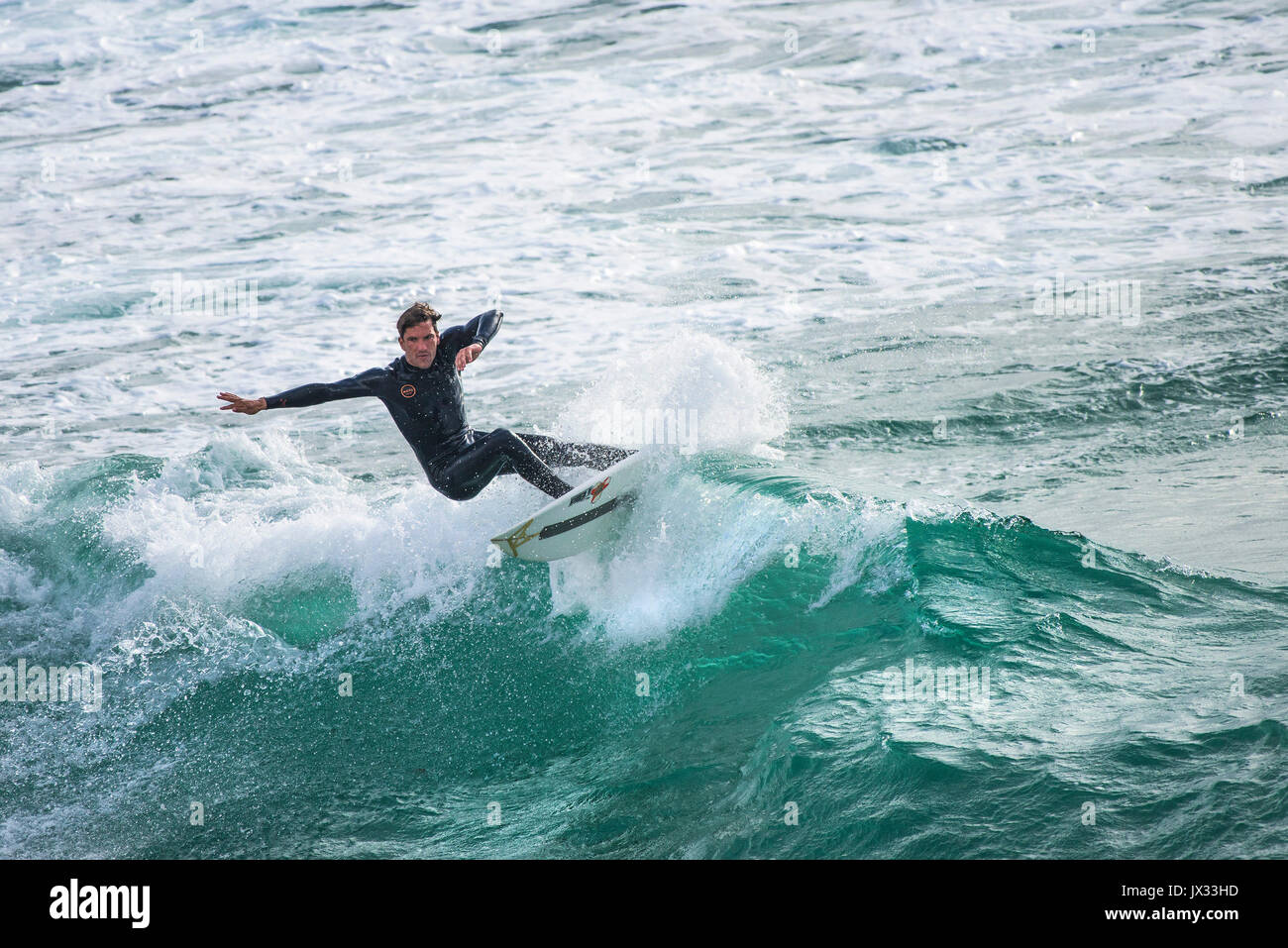 UK Surf. Un surfer une vague à dans Fistral Newquay, Cornwall. Banque D'Images