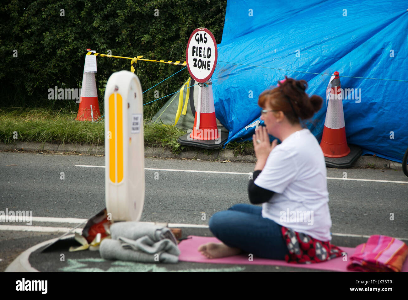 Les militants anti-fracturation et manifestants devant les portes de la Quadrilla site fracturation 31 juin, Lancashire, Royaume-Uni. Une femme prie à l'extérieur de la Banque D'Images