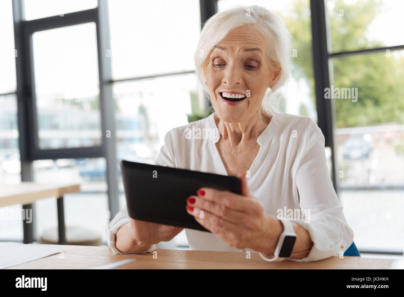 Cheerful ravi à la femme à l'écran de tablette Banque D'Images