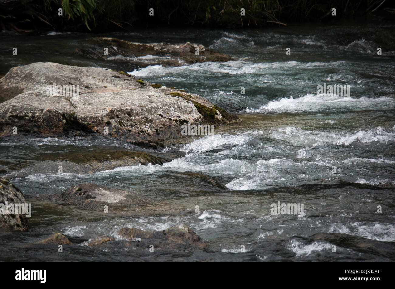 Des pierres dans une rivière de montagne. L'écoulement de l'eau rapide dans la rivière dans l'arrière-plan. Banque D'Images