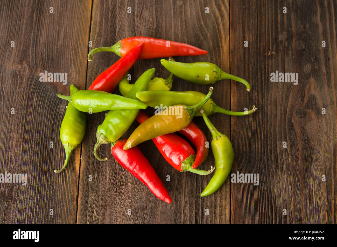 Petits piments colorés sur une table en bois Banque D'Images